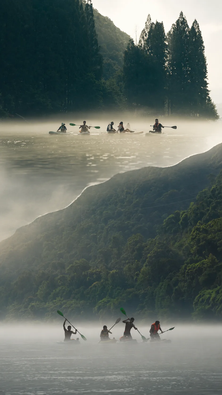 A group paddling through morning mist with forested hills around Jiande.